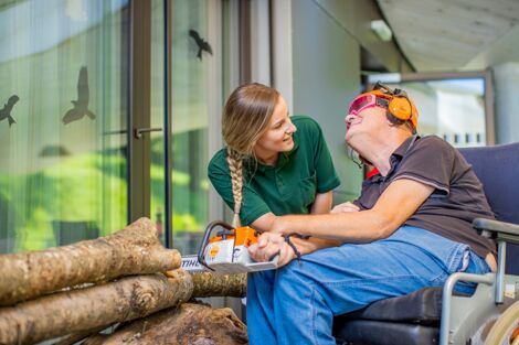 Bewohner mit Therapeutin beim Holzschneiden - Wohnbereich Salzkristall